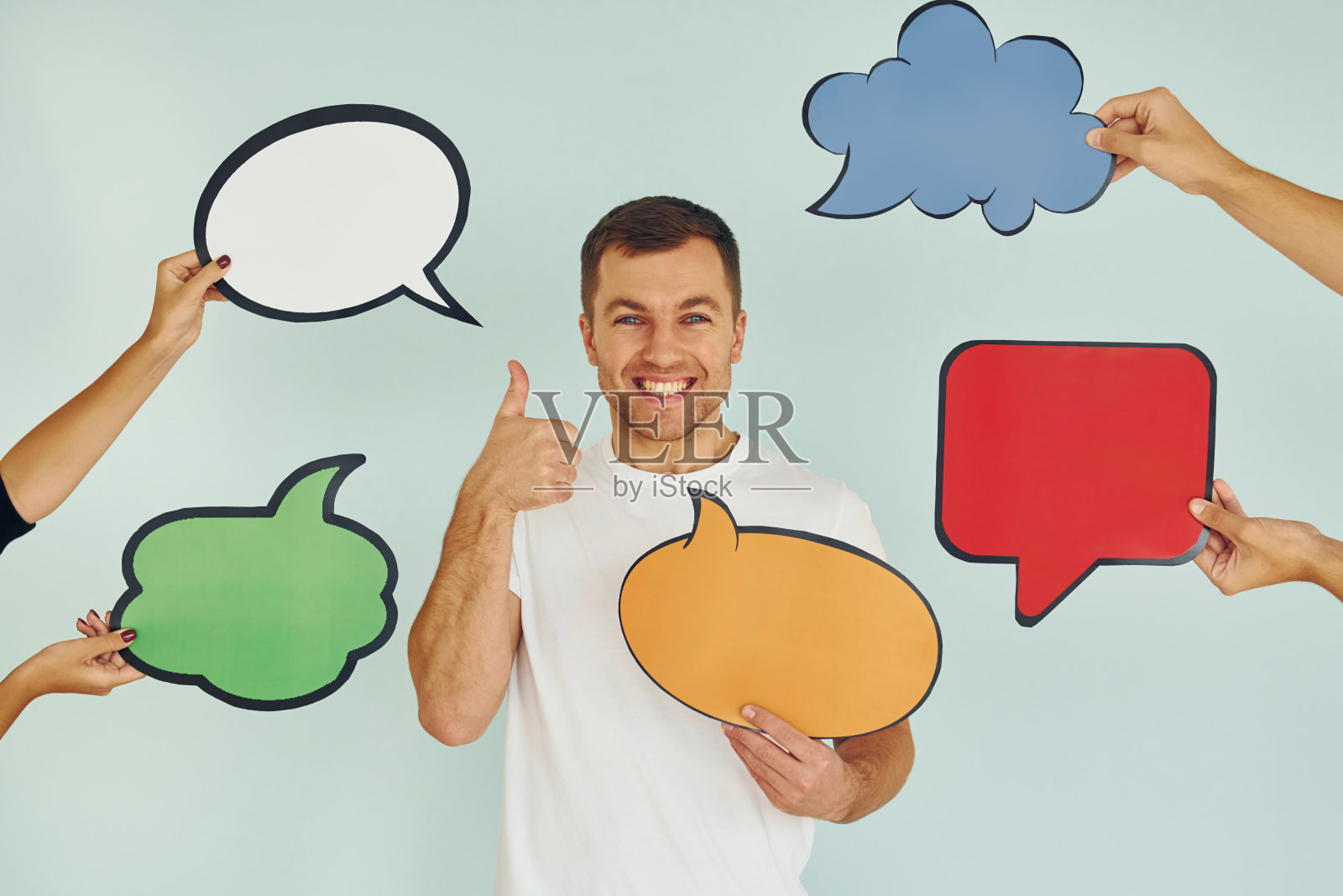 很多不同的想法。一个男人站在画室里，手里拿着空白的牌子照片摄影图片