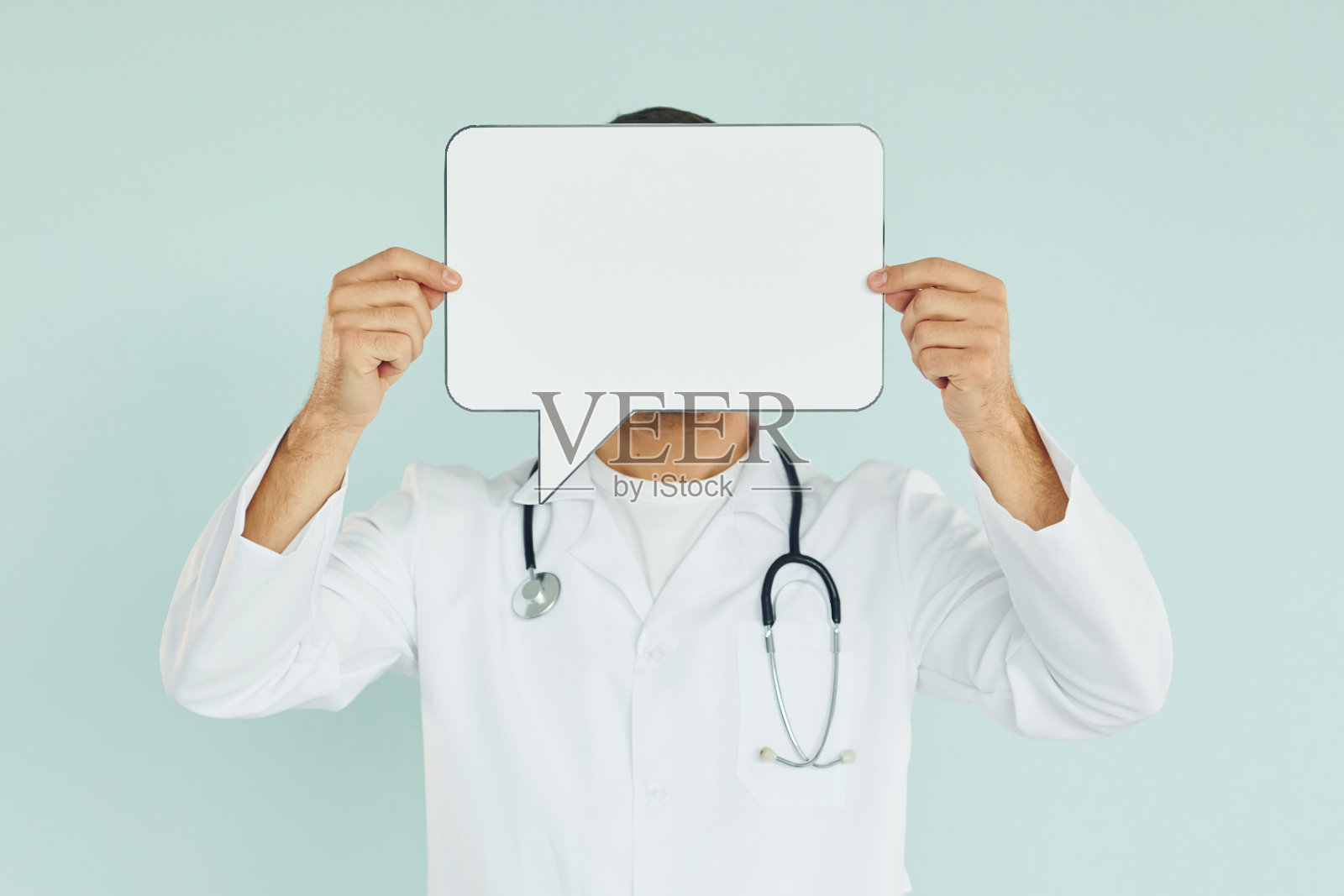 年轻的医生。一个男人站在画室里，手里拿着空白的牌子照片摄影图片