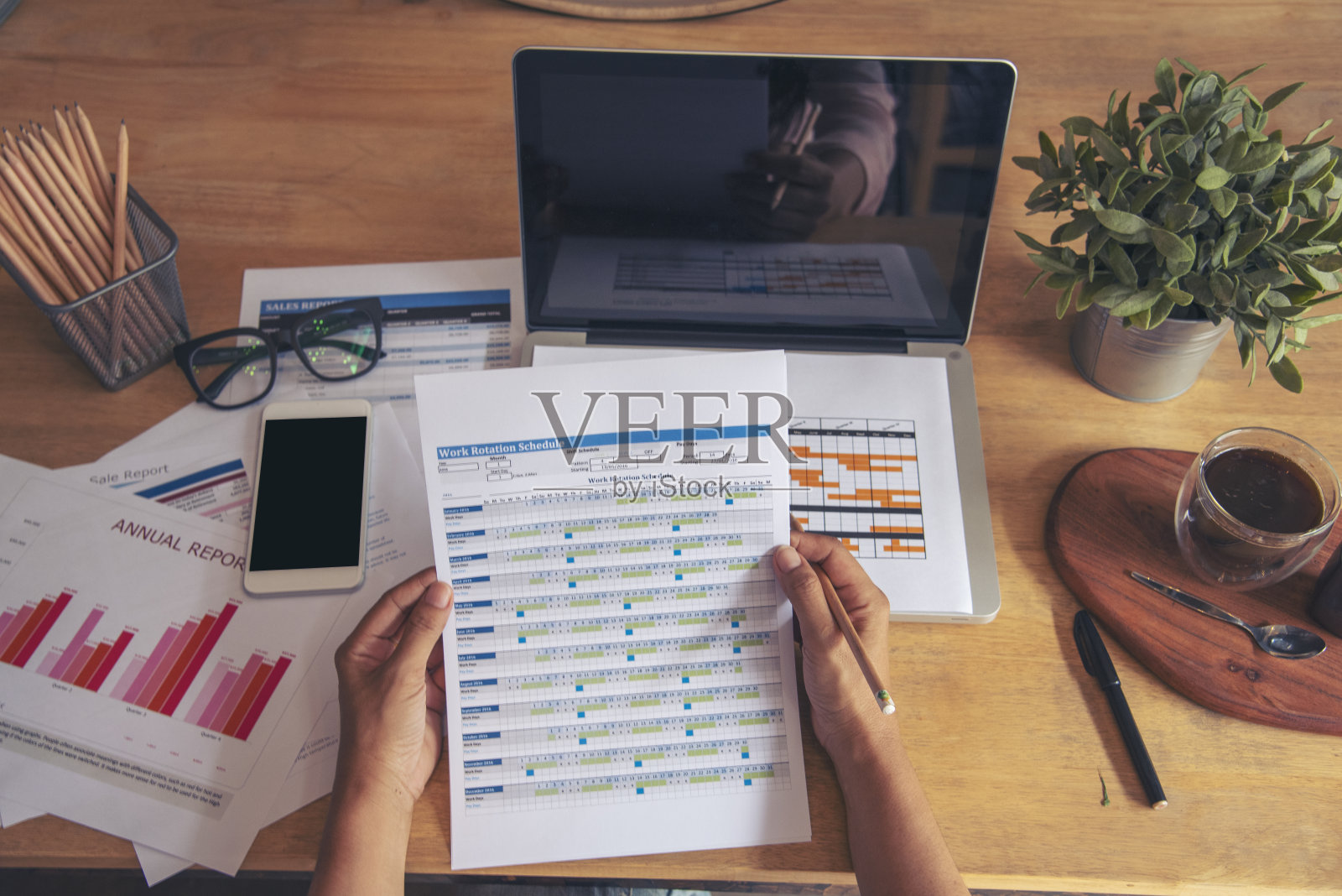 商务女性在办公桌上使用智能手机和笔记本电脑。计划分析市场数据。年轻女性的手在办公室工作，公司的业务信息。照片摄影图片