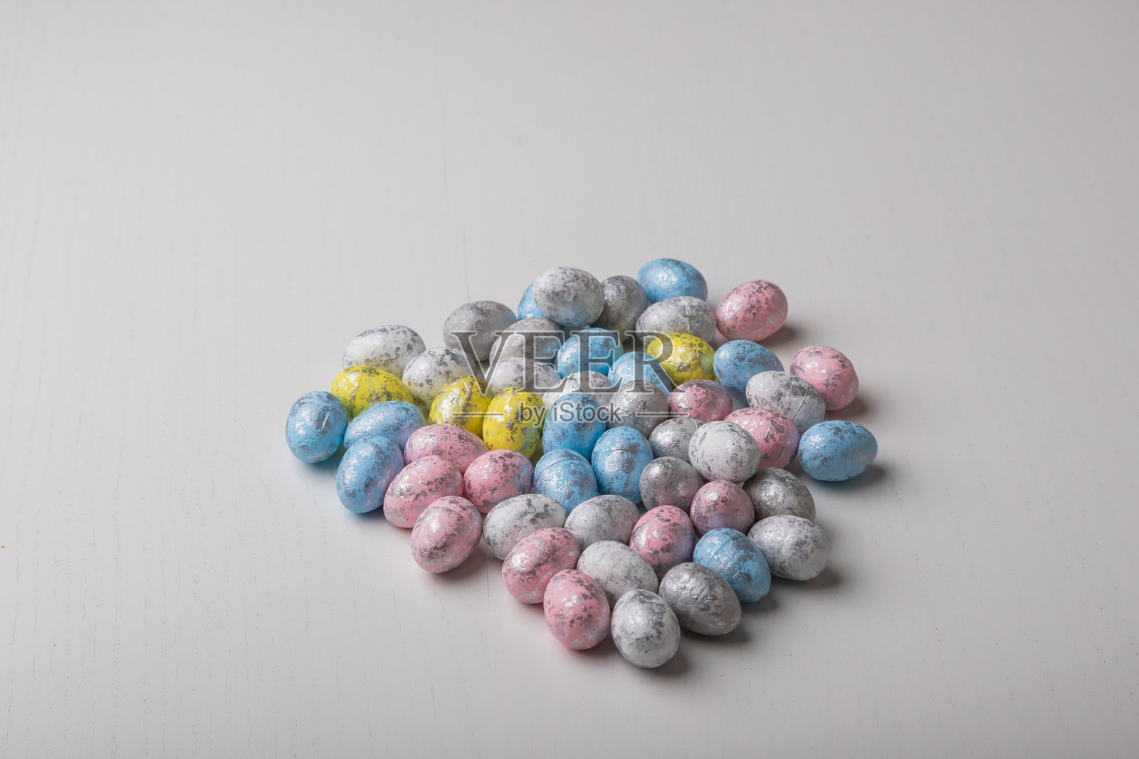 白色的桌子上有彩色的小复活节彩蛋。照片摄影图片