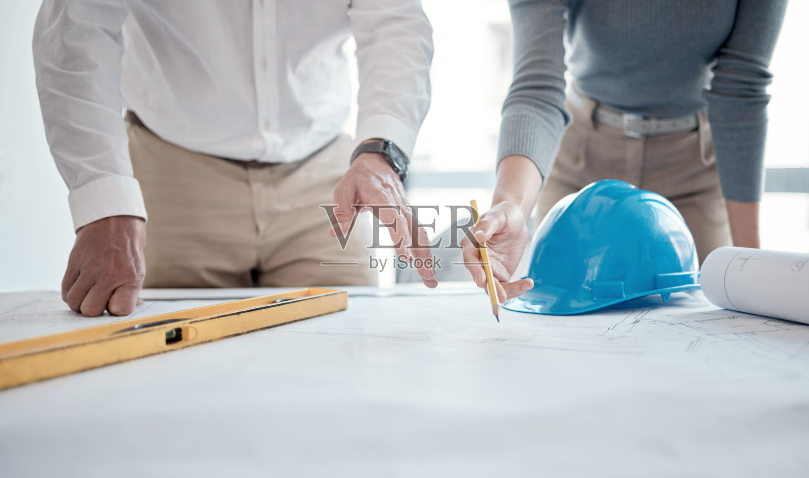 裁切的镜头两个不认识的建筑师在办公室看蓝图照片摄影图片