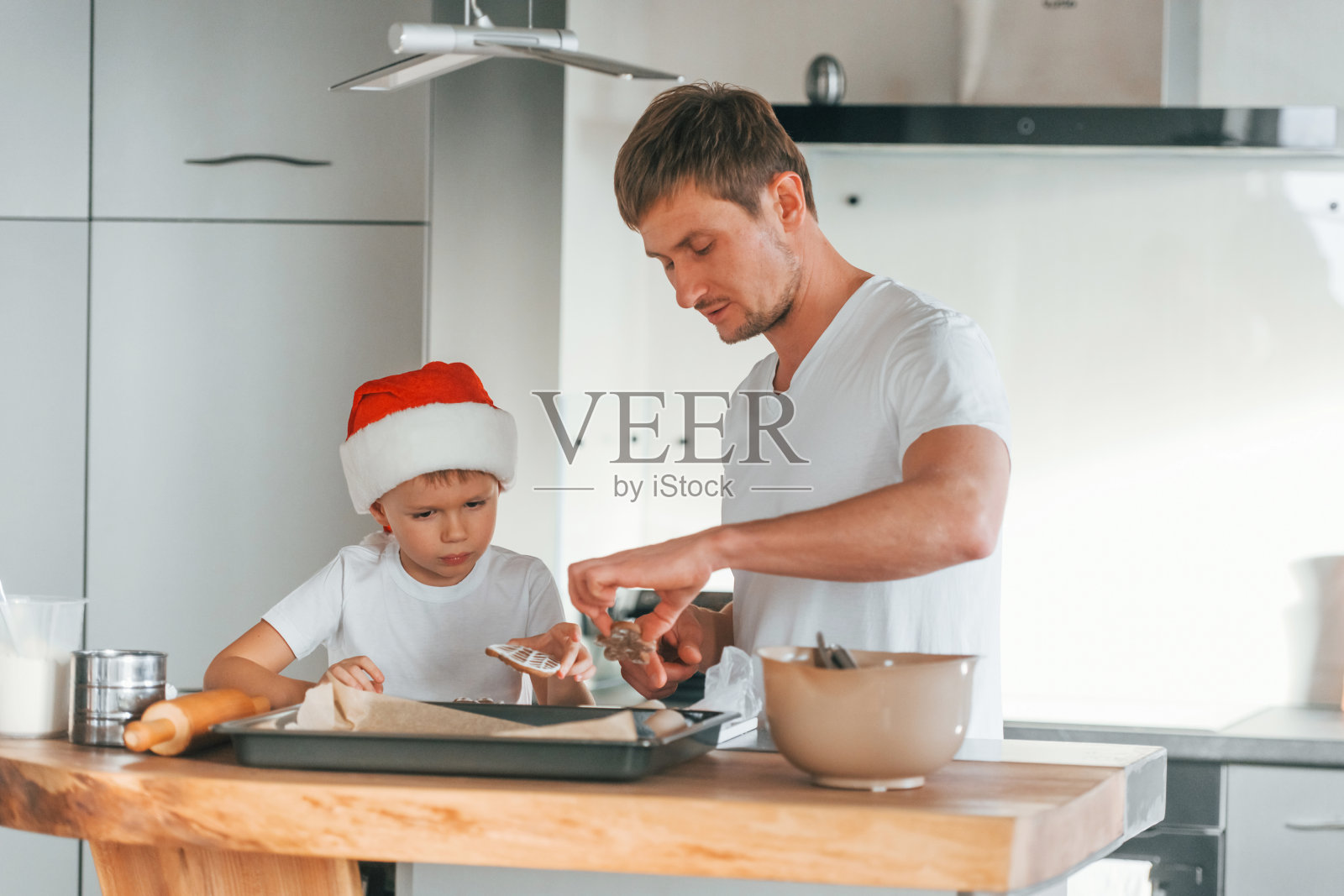 父亲教他的小儿子准备甜美的圣诞饼干照片摄影图片