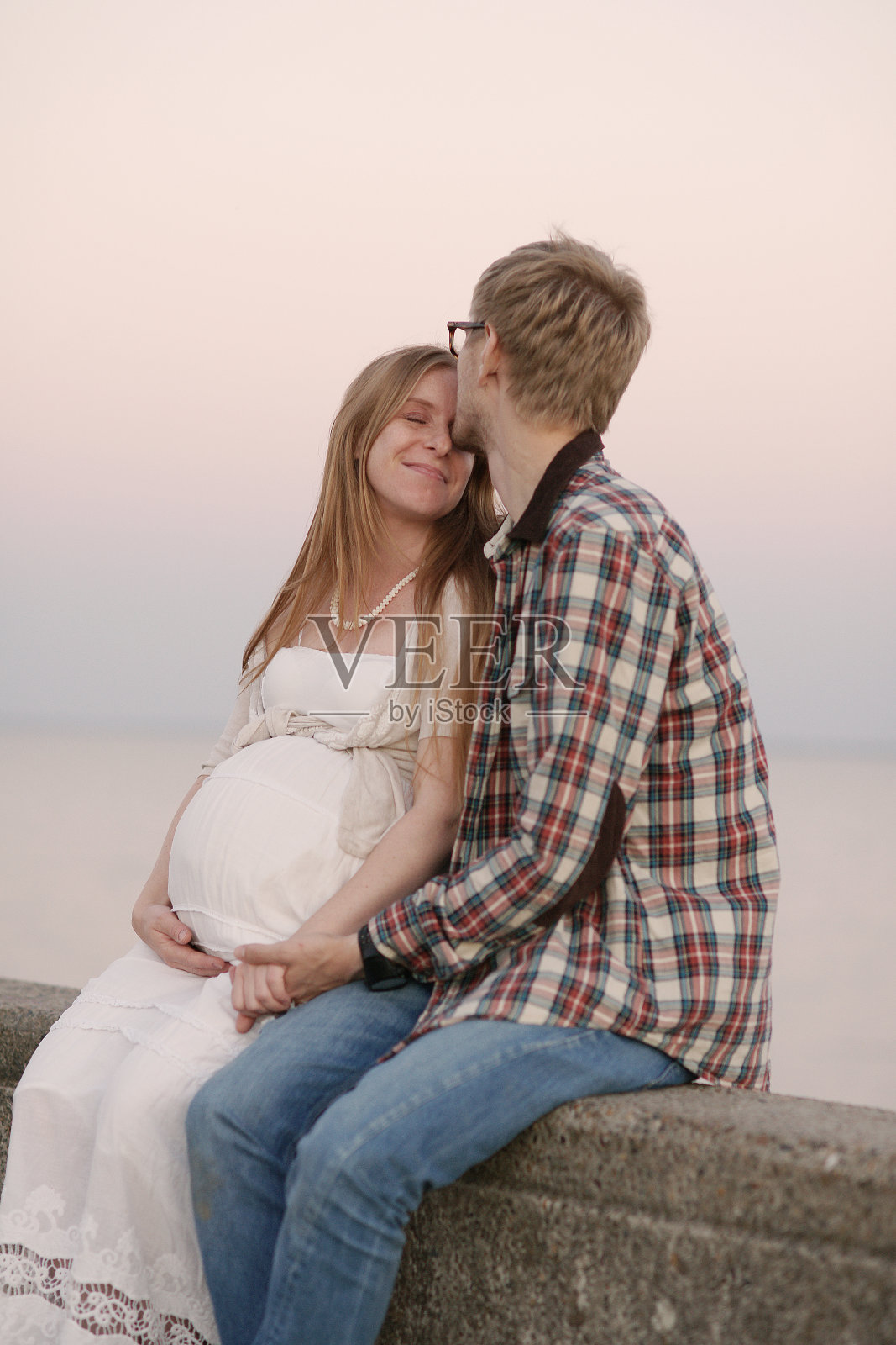 幸福的夫妻。男人亲吻女人。怀孕的女人。照片摄影图片