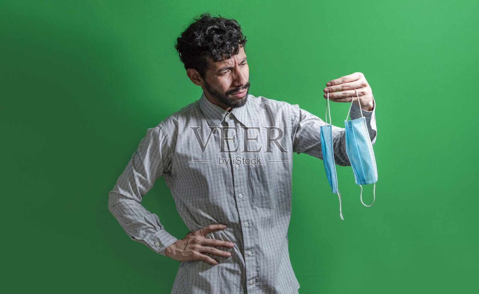 男人决定戴外科口罩，拉丁男人决定在孤立的背景下戴外科口罩"n照片摄影图片