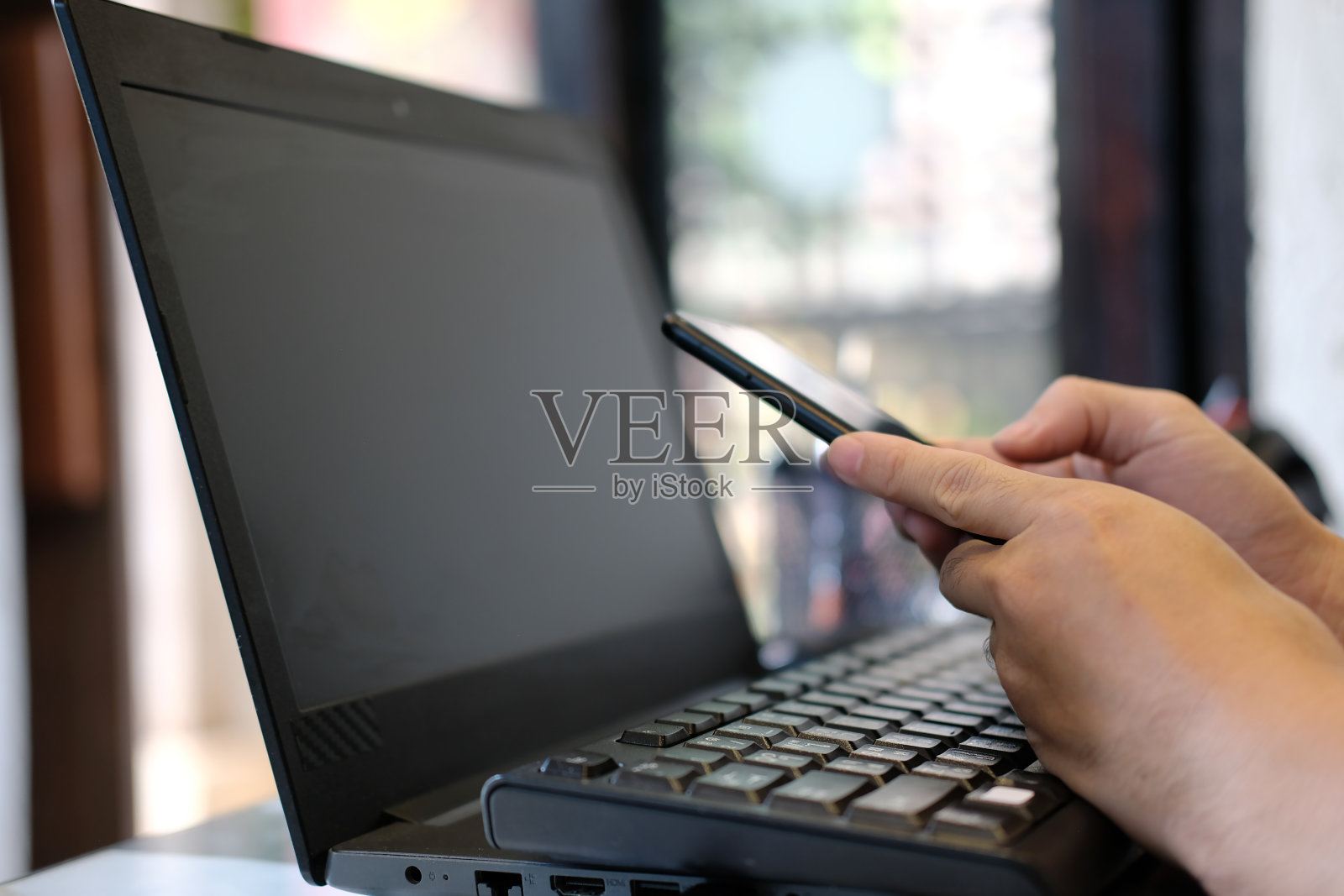 这是一名男子用智能手机拍摄的手部特写，男子正在用手机输入社交媒体信息。照片摄影图片