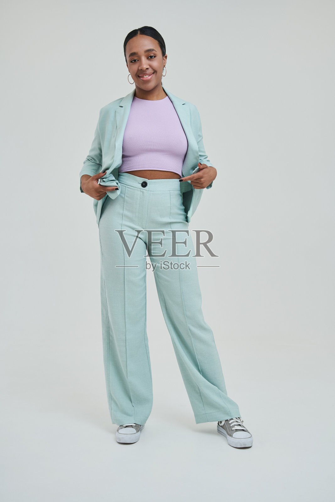 喜出望外的黑发女孩看着相机，而摆姿势在工作室照片摄影图片