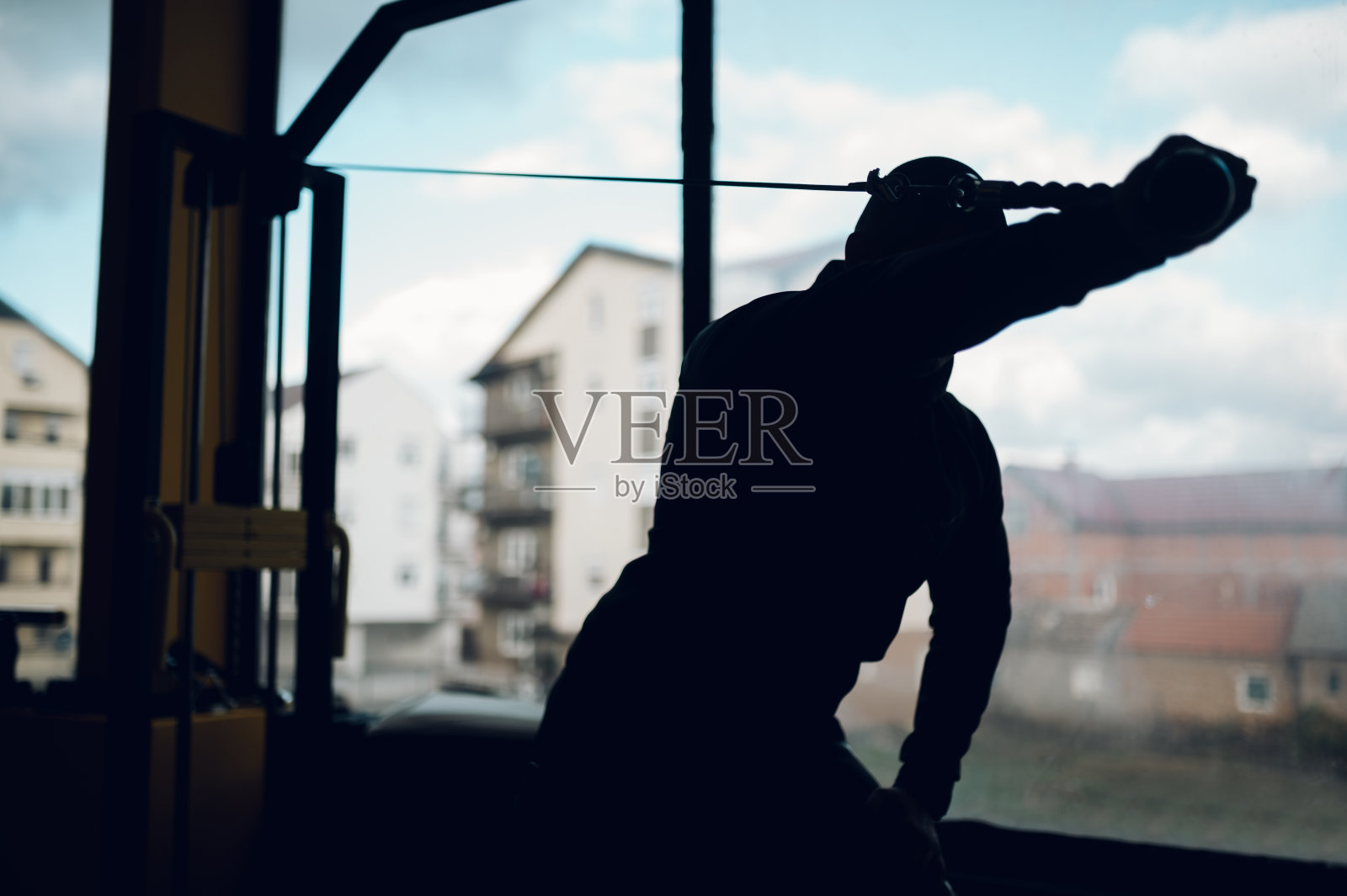 在健身房使用交叉器械的男人。照片摄影图片