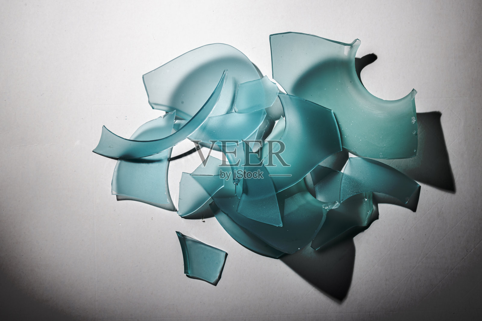 彩色渐变背景上破碎的彩色玻璃碎片。照片摄影图片