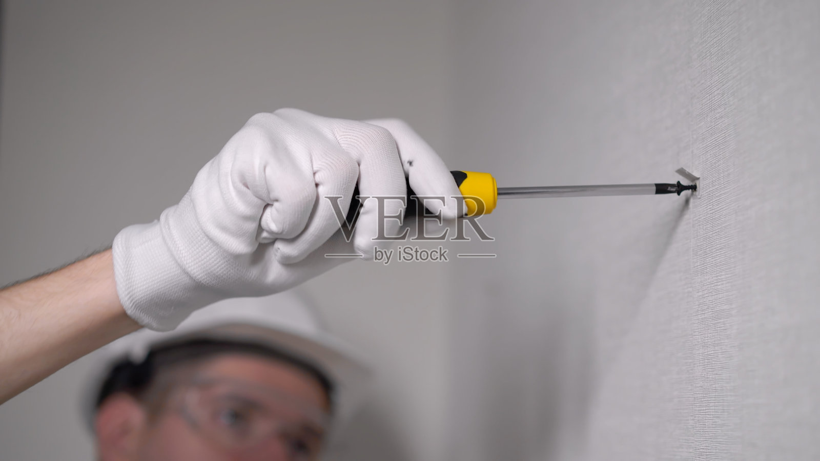 建筑工人在公寓里用螺丝修理水泥墙照片摄影图片