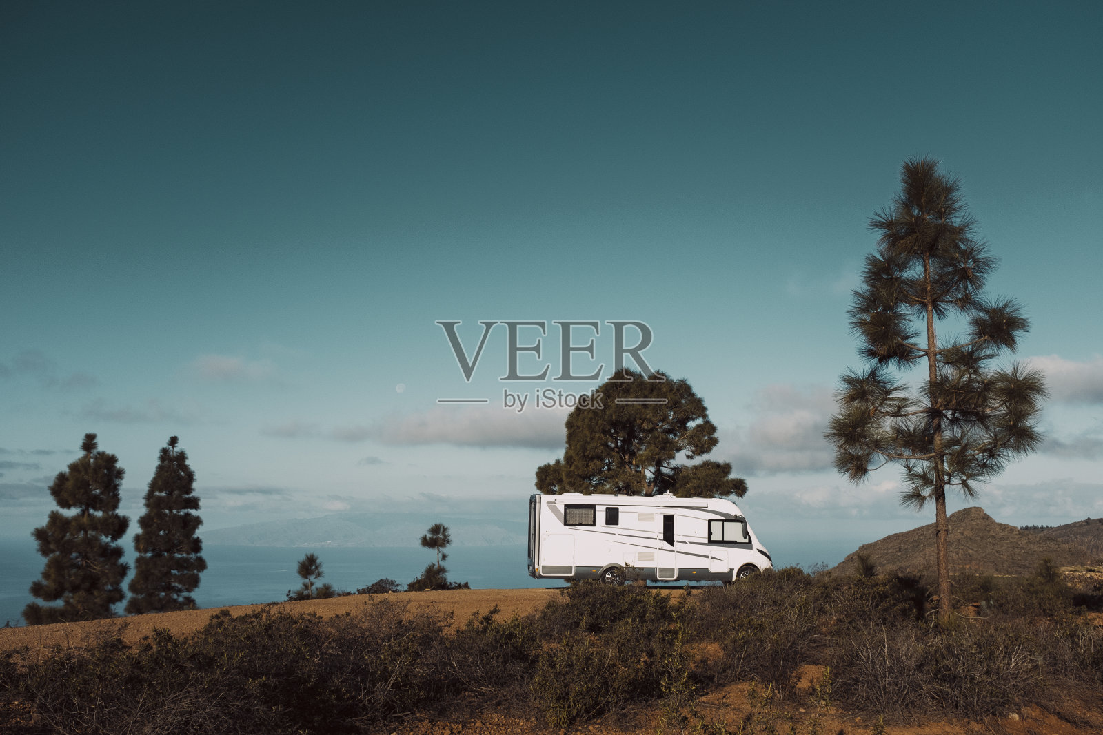 现代露营车房车停在自然与天空的观点。人与旅游车辆度假的概念。冒险vanlife生活方式和游牧生活。夏季露营地假期。照片摄影图片