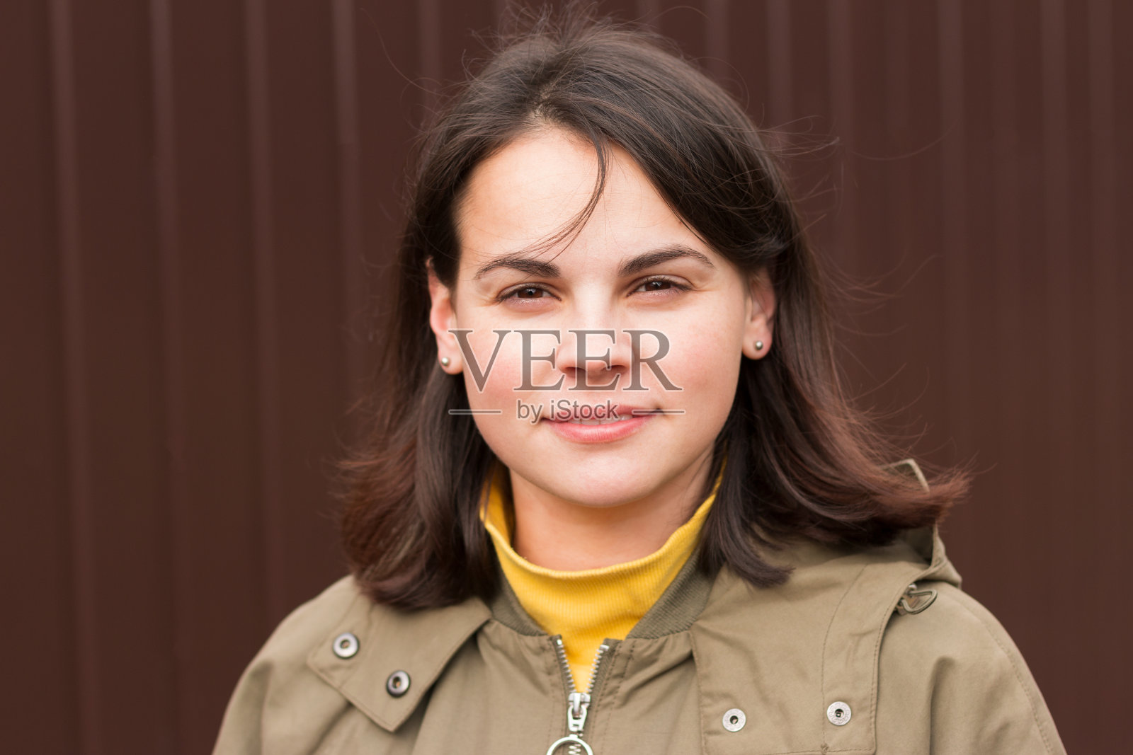 美丽可爱的微笑女孩在休闲夹克和黑色的头发站在秋天的背景照片摄影图片