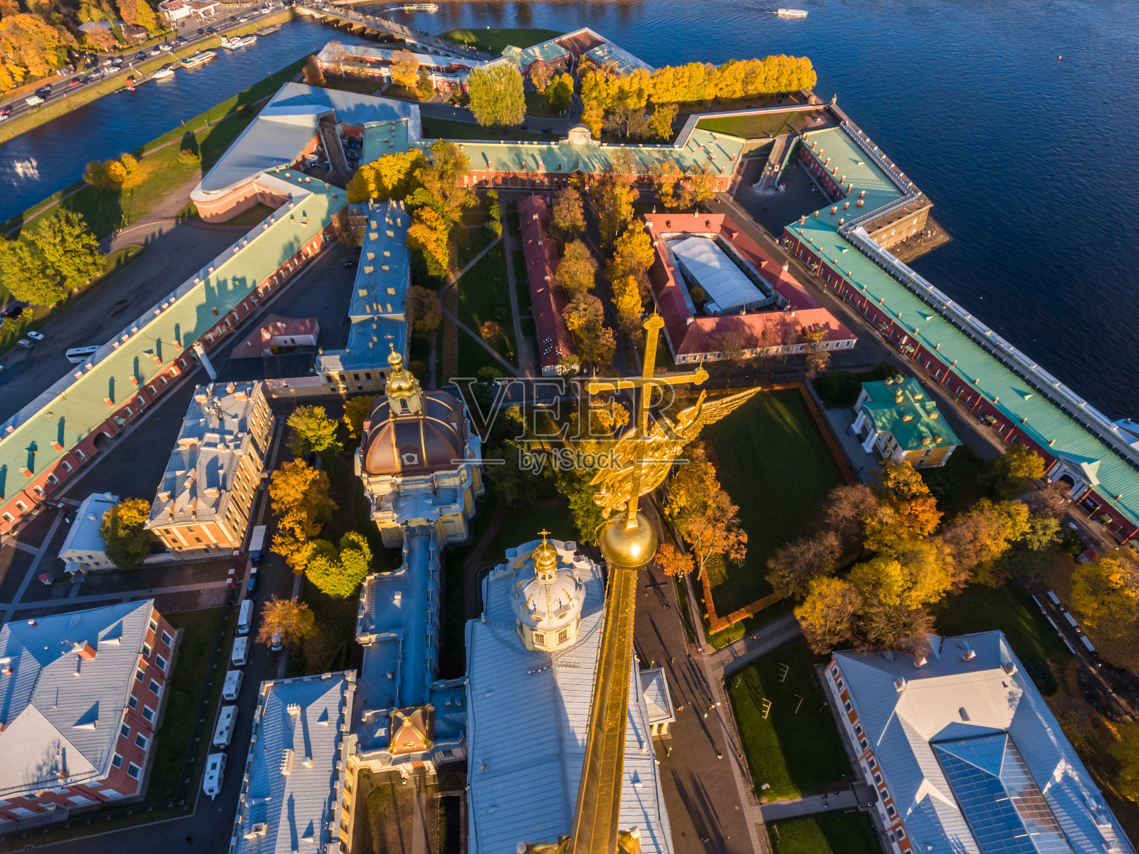 俄罗斯，圣彼得堡，日落时彼得和保罗大教堂的空中景观，堡垒的墙壁，金色的秋天，全景景观，金色的塔尖与十字架和天使，吊桥，涅瓦河照片摄影图片