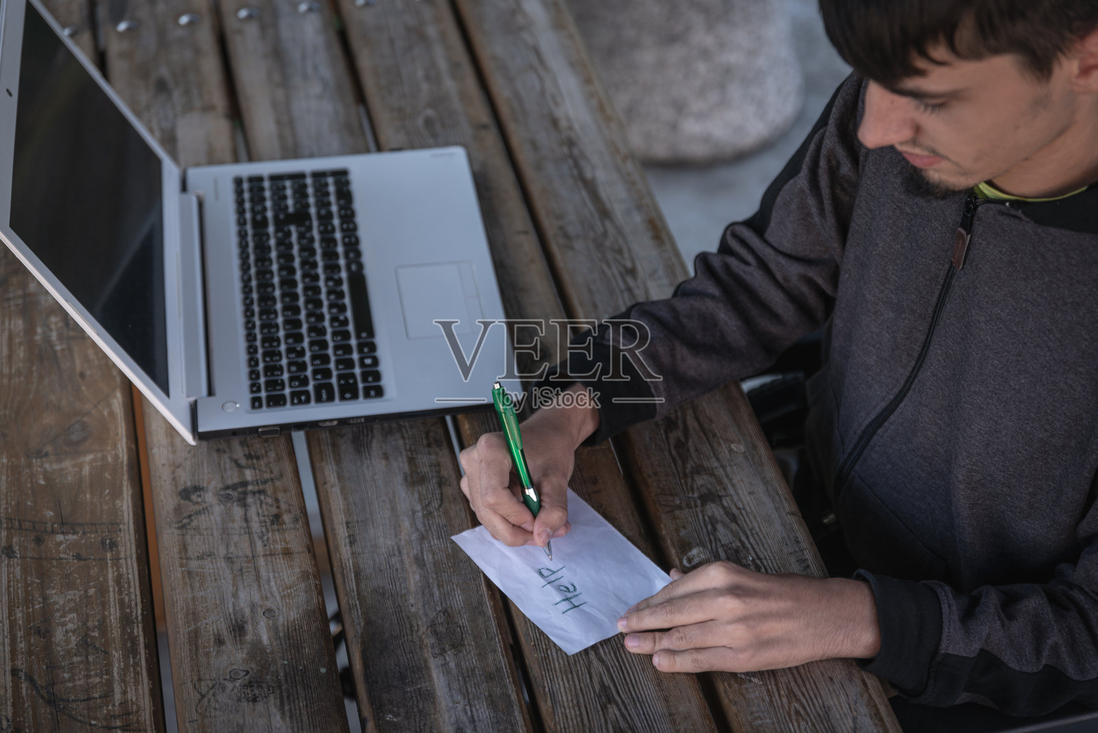 一个真正的残疾人坐在轮椅上，通过电子设备，电脑，电话与世界交流。照片摄影图片