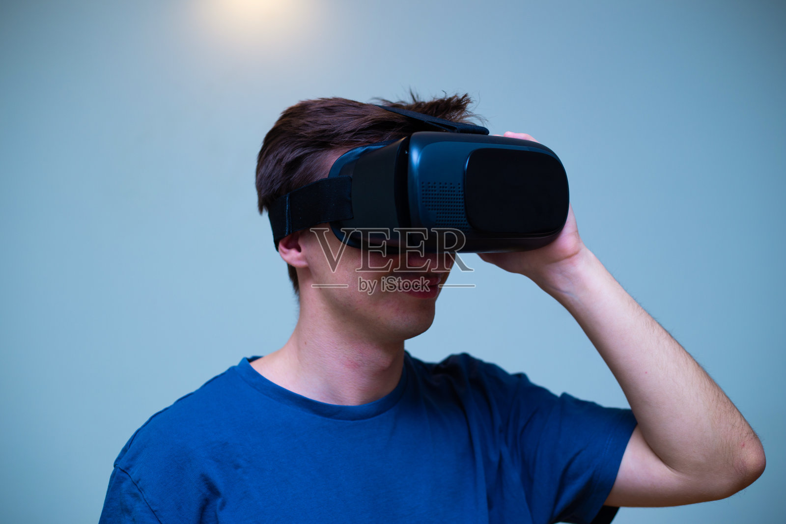 一个戴着虚拟现实眼镜的年轻人兴奋地沉浸在超时空中照片摄影图片