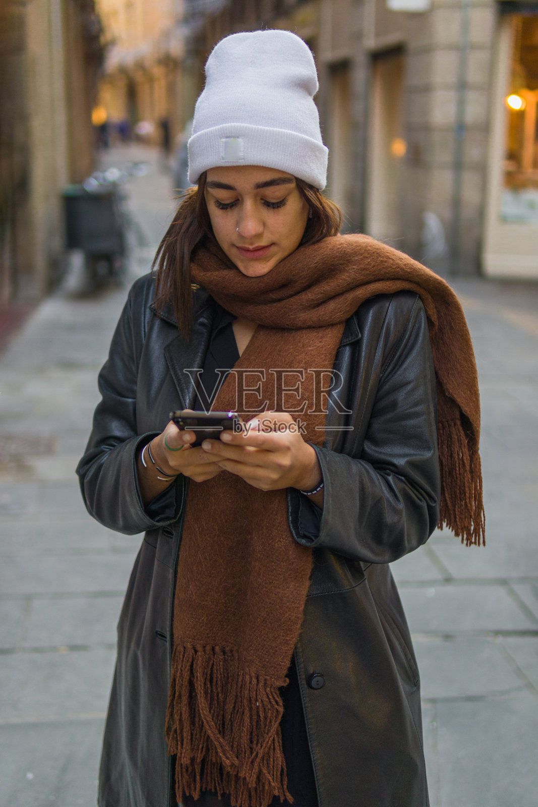 美丽的女人与拉丁特征短信与她的手机照片摄影图片