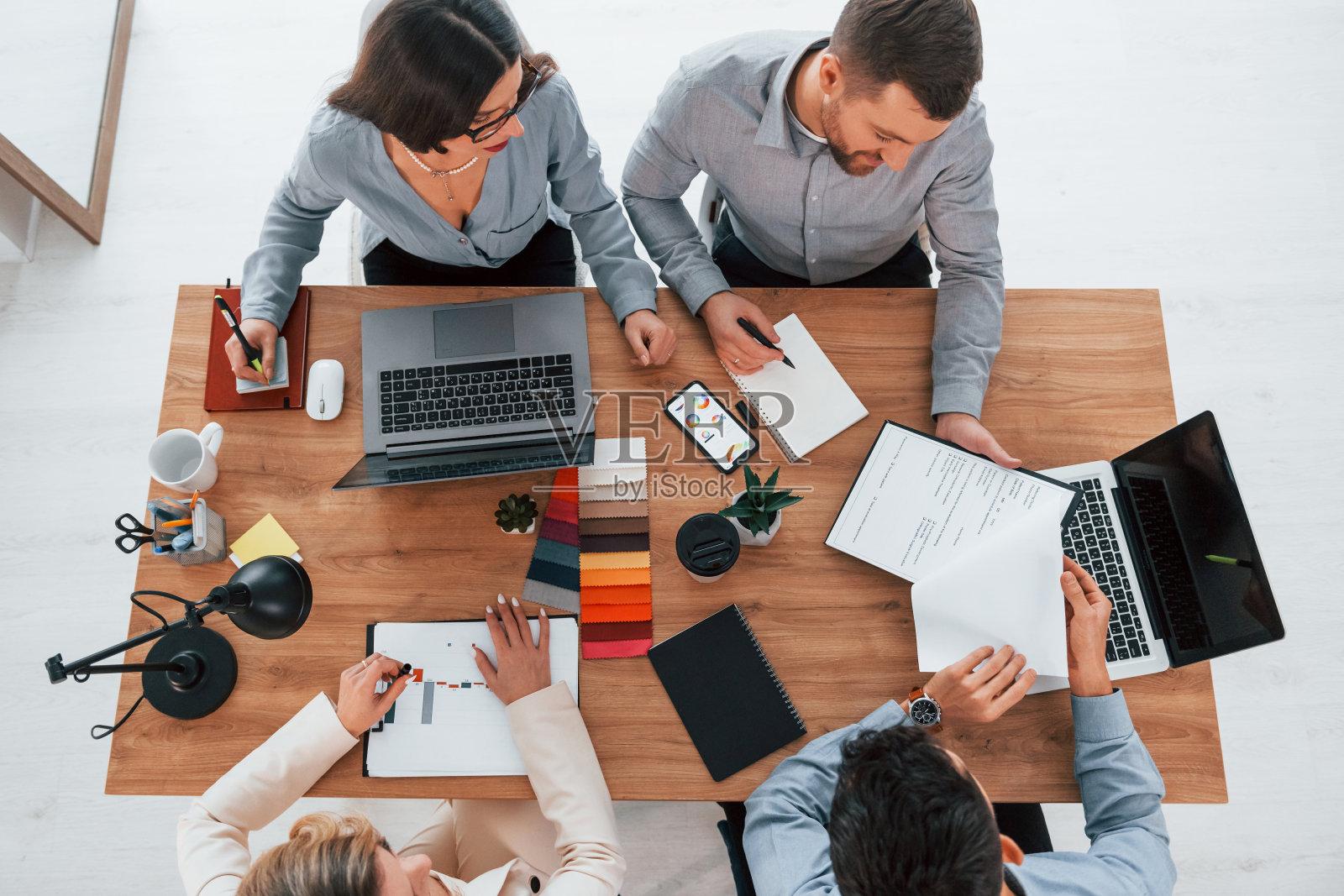 在谈话。在办公室里为这个项目工作的一群商务人士照片摄影图片