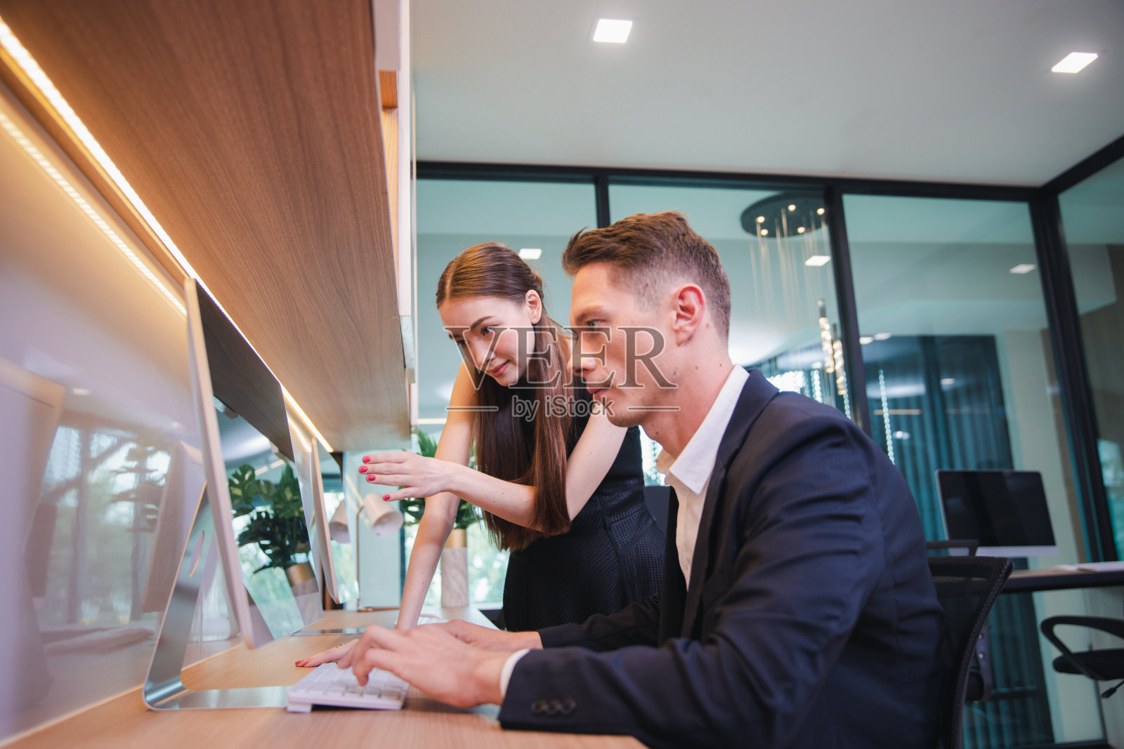 两个业务同事在现代办公室工作讨论照片摄影图片