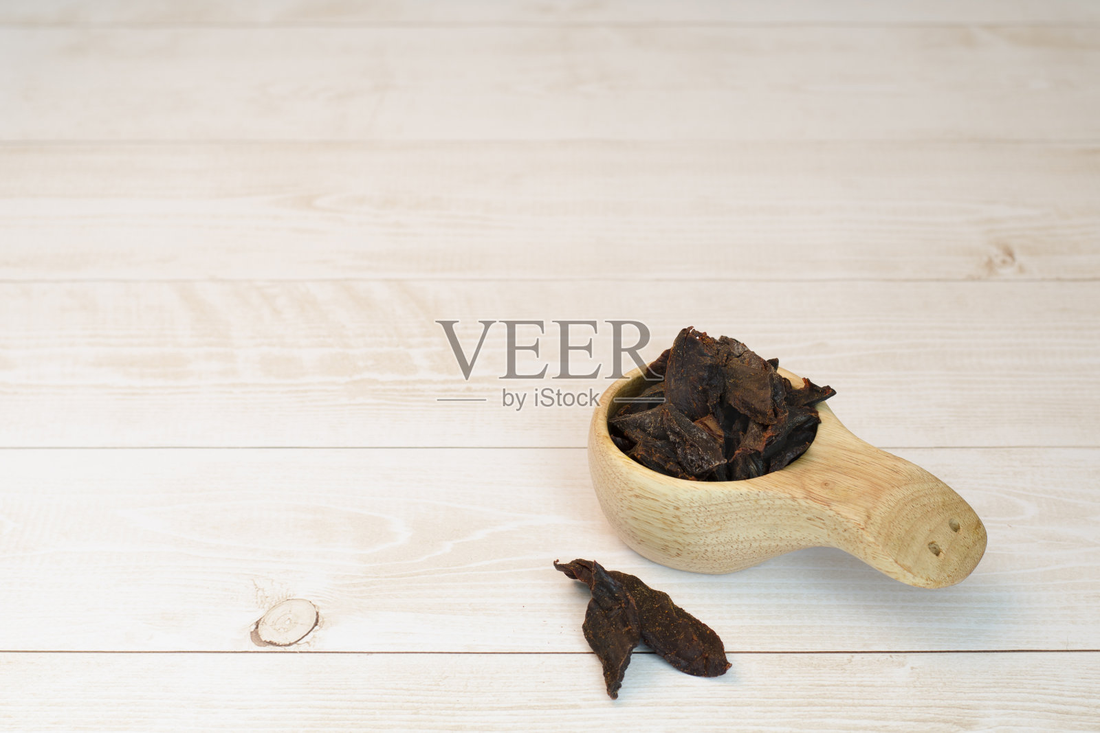 木制背景上的牛肉干。牛肉干。照片摄影图片