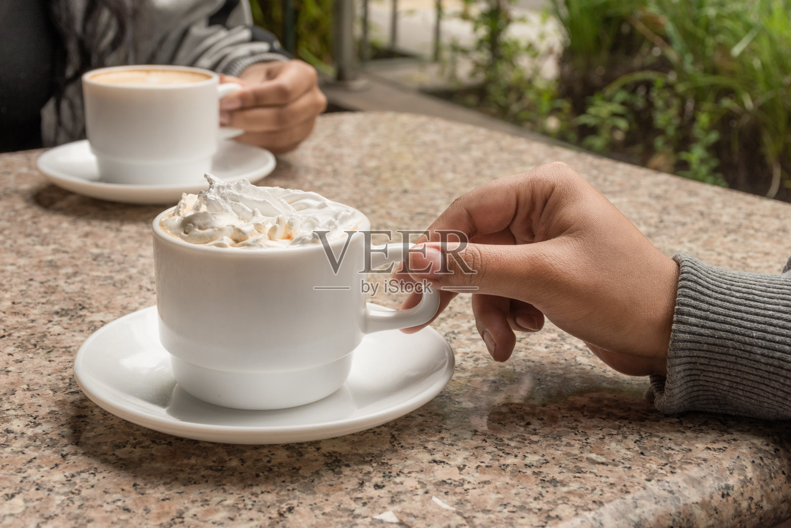在餐厅分享一杯加奶油的咖啡，手的细节，生活方式，早餐喝什么照片摄影图片