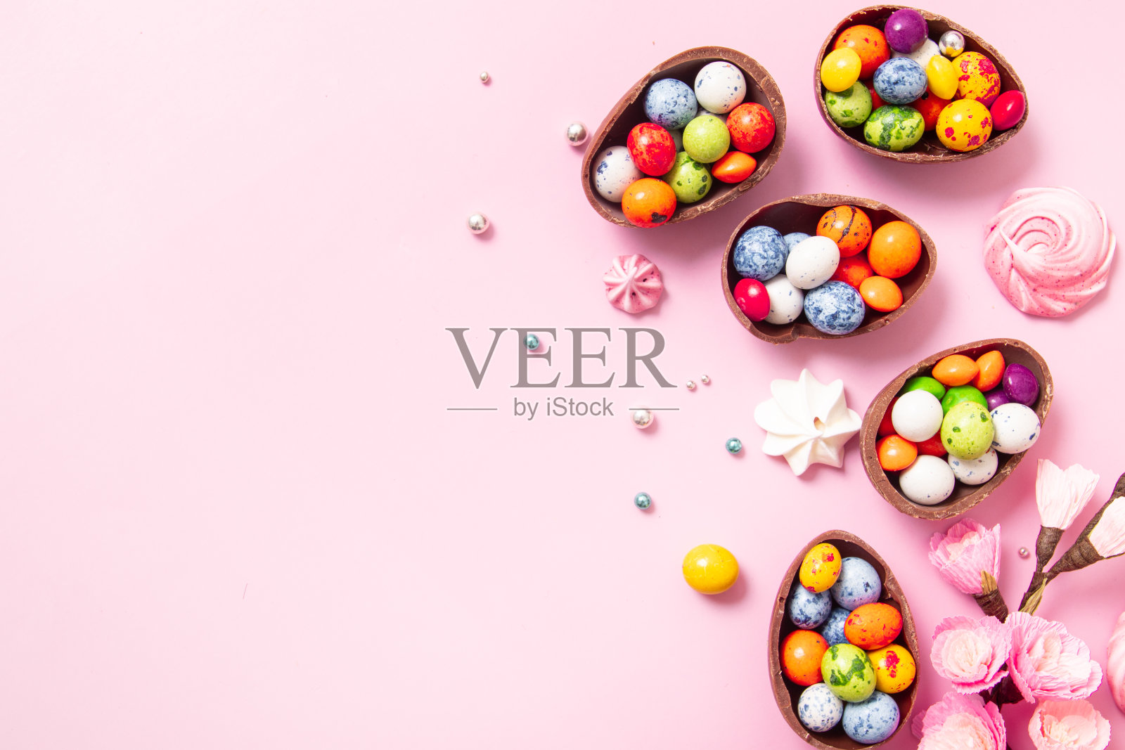 巧克力复活节蛋和装饰平躺为孩子复活节狩猎蛋概念在粉红色的背景。鸡蛋形状的糖果照片摄影图片