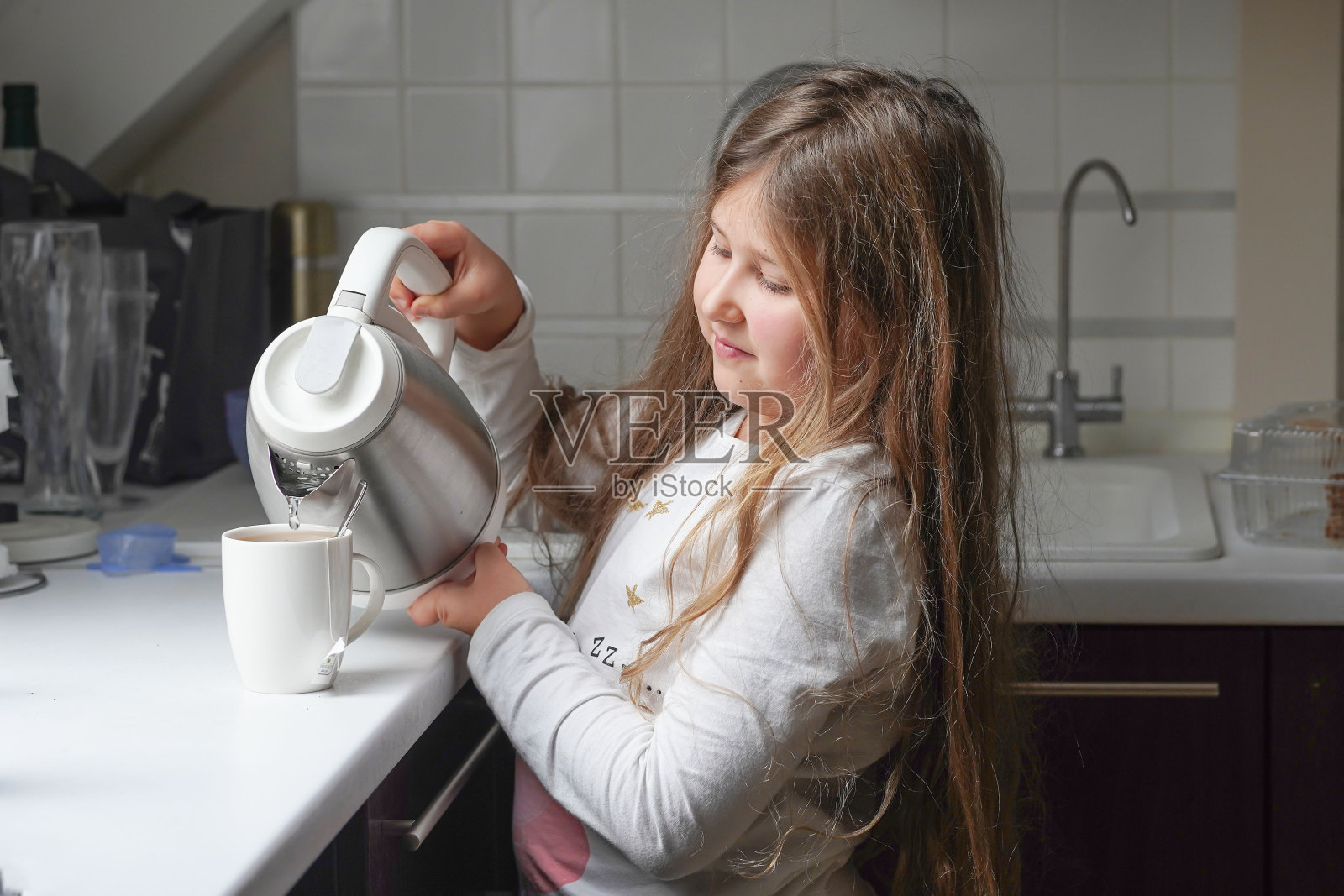 一个小女孩在家帮忙做早餐。家庭、隔离、家庭教育理念。照片摄影图片