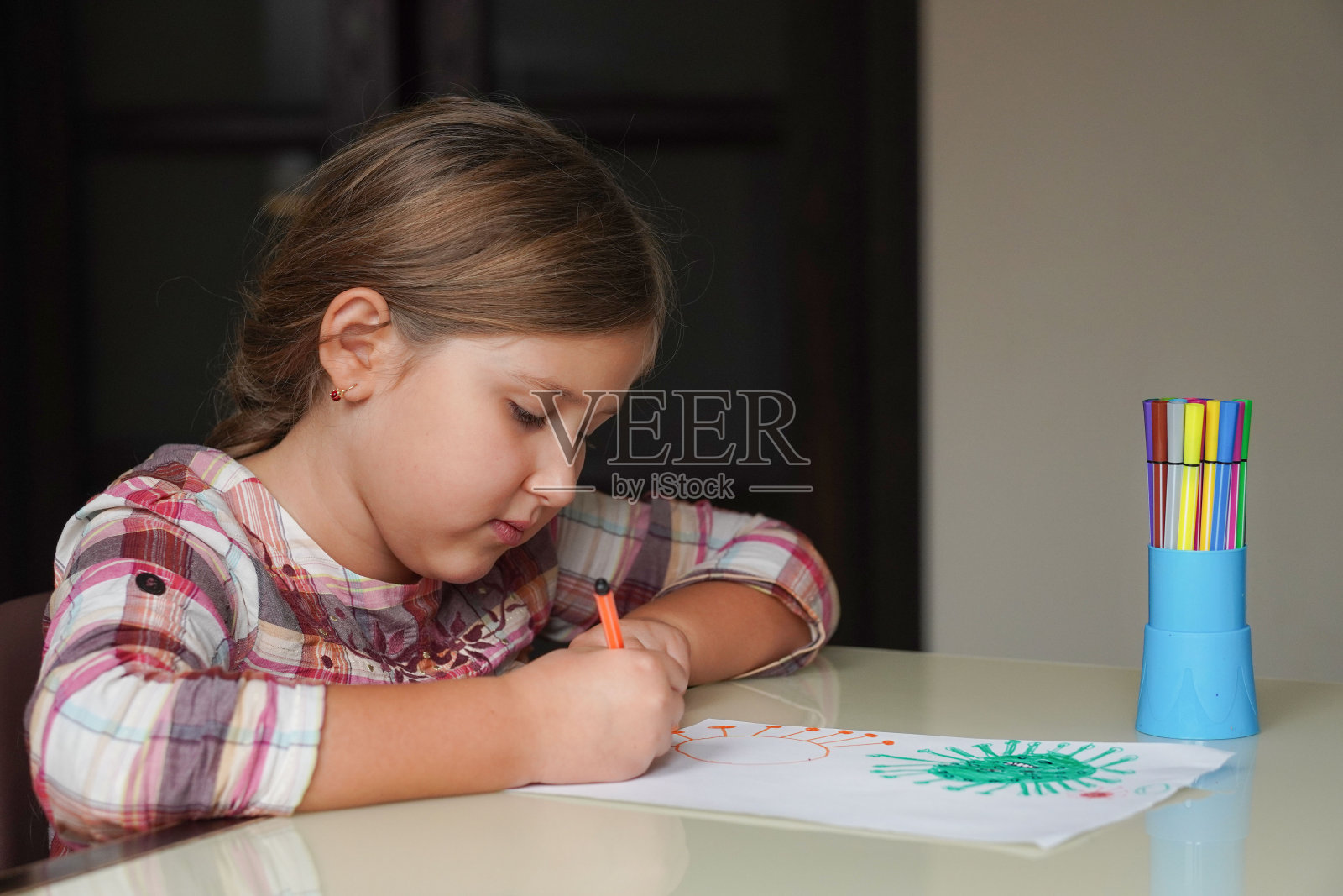 可爱的小女孩用毡尖笔拿着她画的冠状病毒分子Omicron。世界卫生冠状病毒爆发传染病和全球致命病毒健康风险和流感传播或冠状病毒流感。接种疫苗的概念。照片摄影图片