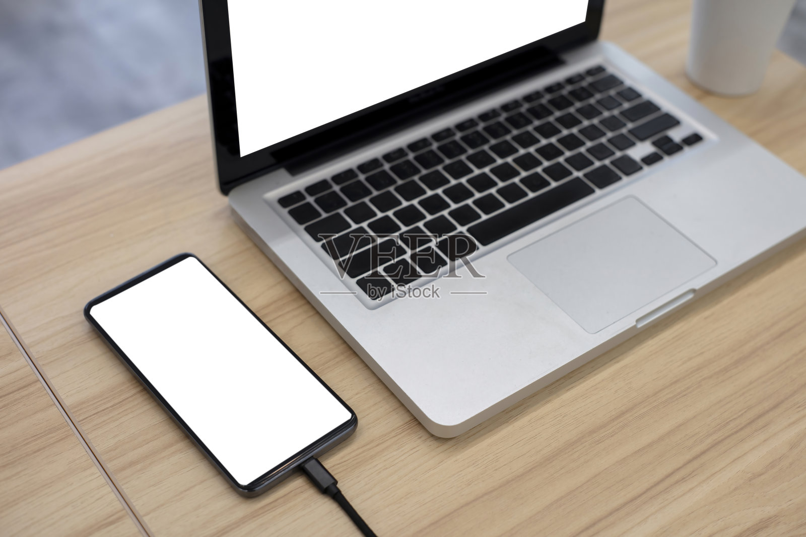 桌上放着黑屏手机和笔记本电脑照片摄影图片