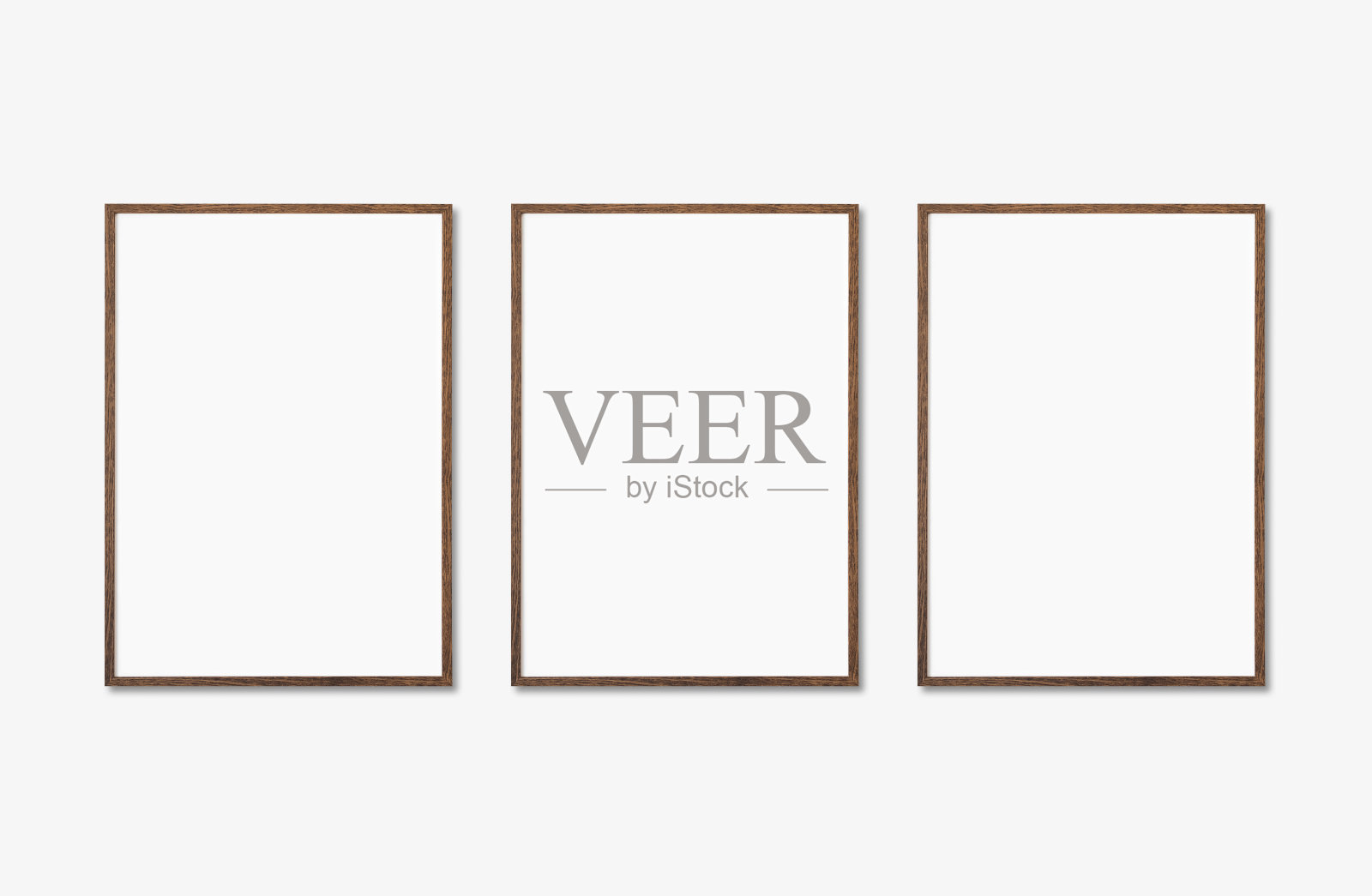 墙上有三个垂直的白画框。艺术品模拟了孤立照片摄影图片