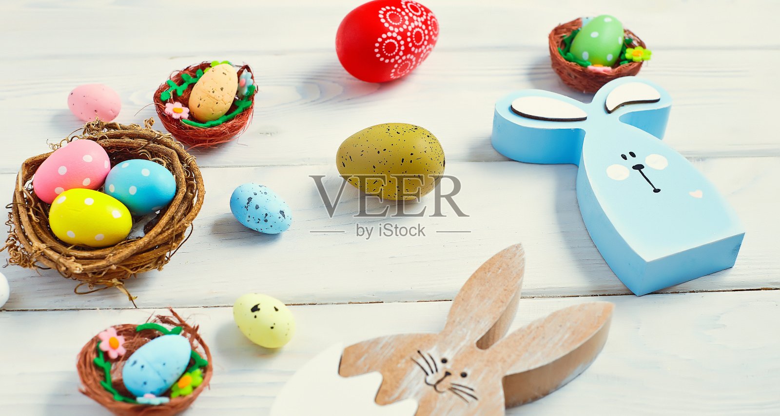 色彩鲜艳的复活节蛋在巢与空间的木材背景。最小的概念。带有文本复制空间的卡片。照片摄影图片