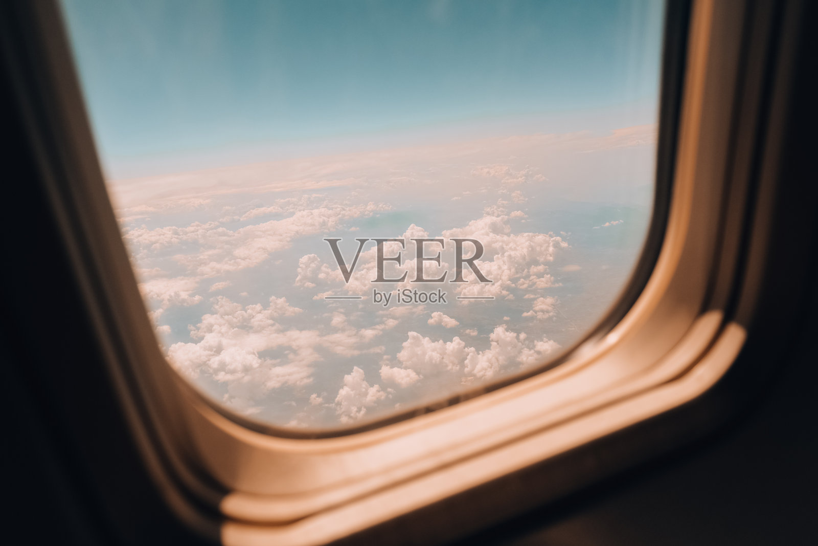 飞机飞行。从飞机窗口看到的景色。飞机,飞机。乘飞机旅行。令人惊叹的金色蓬松的云轻轻移动照片摄影图片