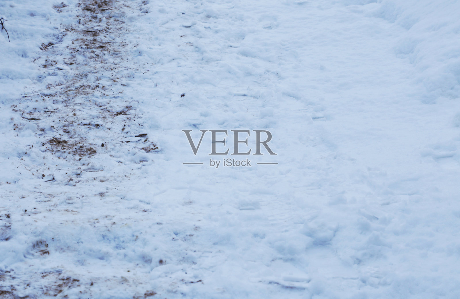 楼梯上覆盖着雪，有脚印和泥土。照片摄影图片