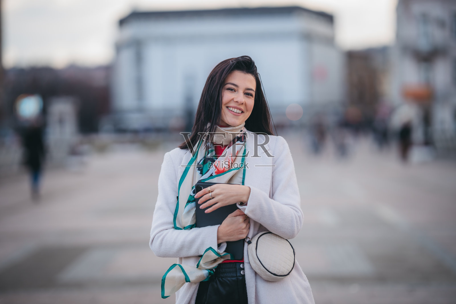 成功的商业女性拿着数码平板电脑在城市中行走照片摄影图片