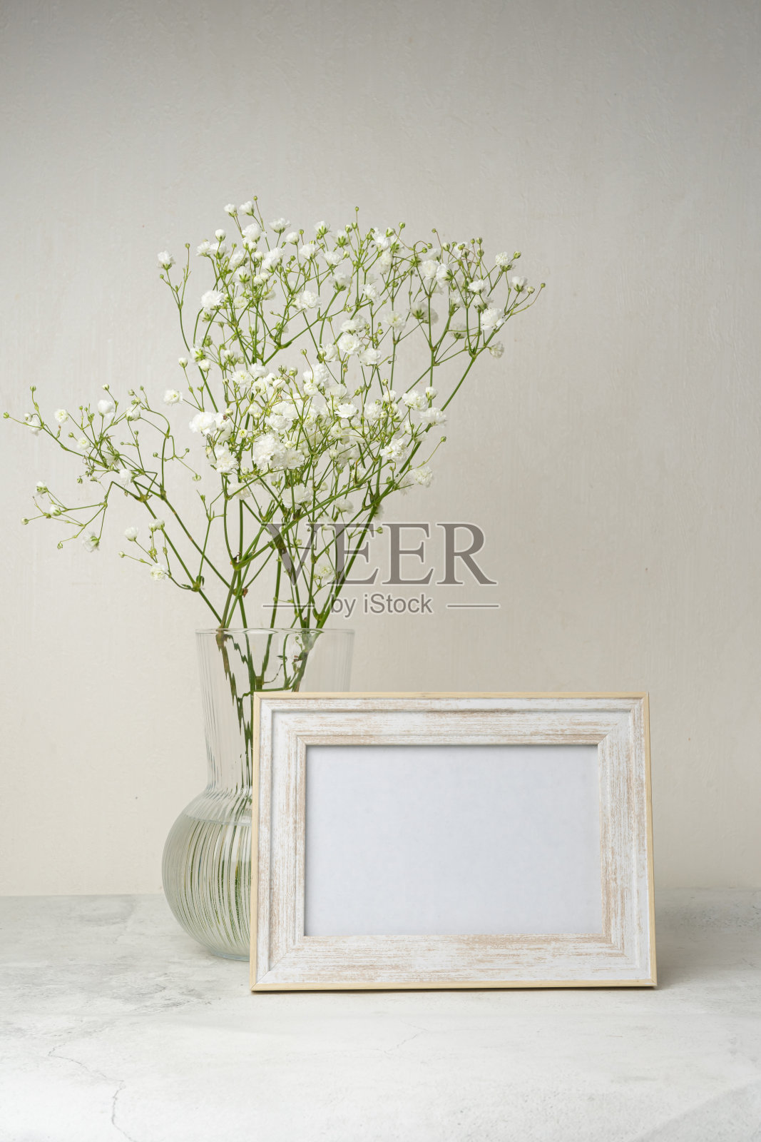人像白色相框模型木桌。现代的陶瓷花瓶上镶满了石膏。北欧室内照片摄影图片