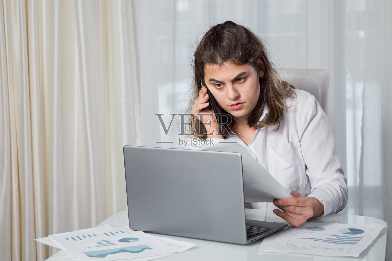 一名残疾妇女在电话里看着项目文件照片摄影图片