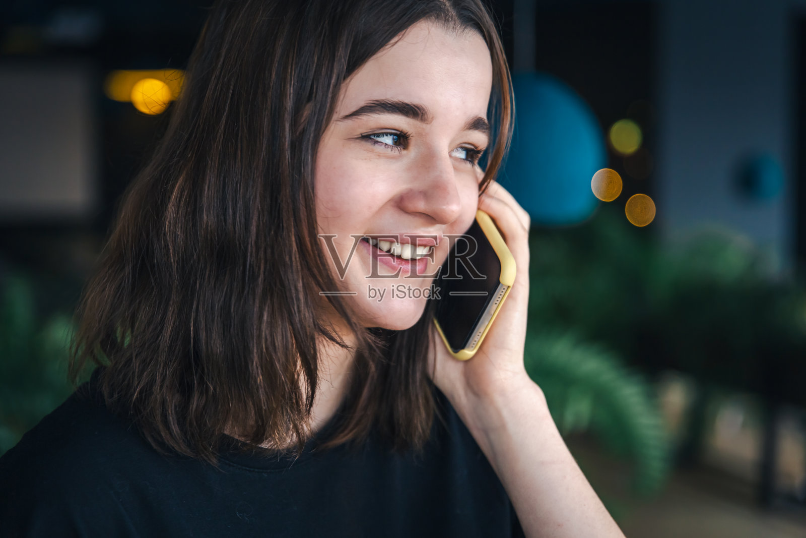 一个年轻女人在打电话，特写镜头，背景模糊。照片摄影图片