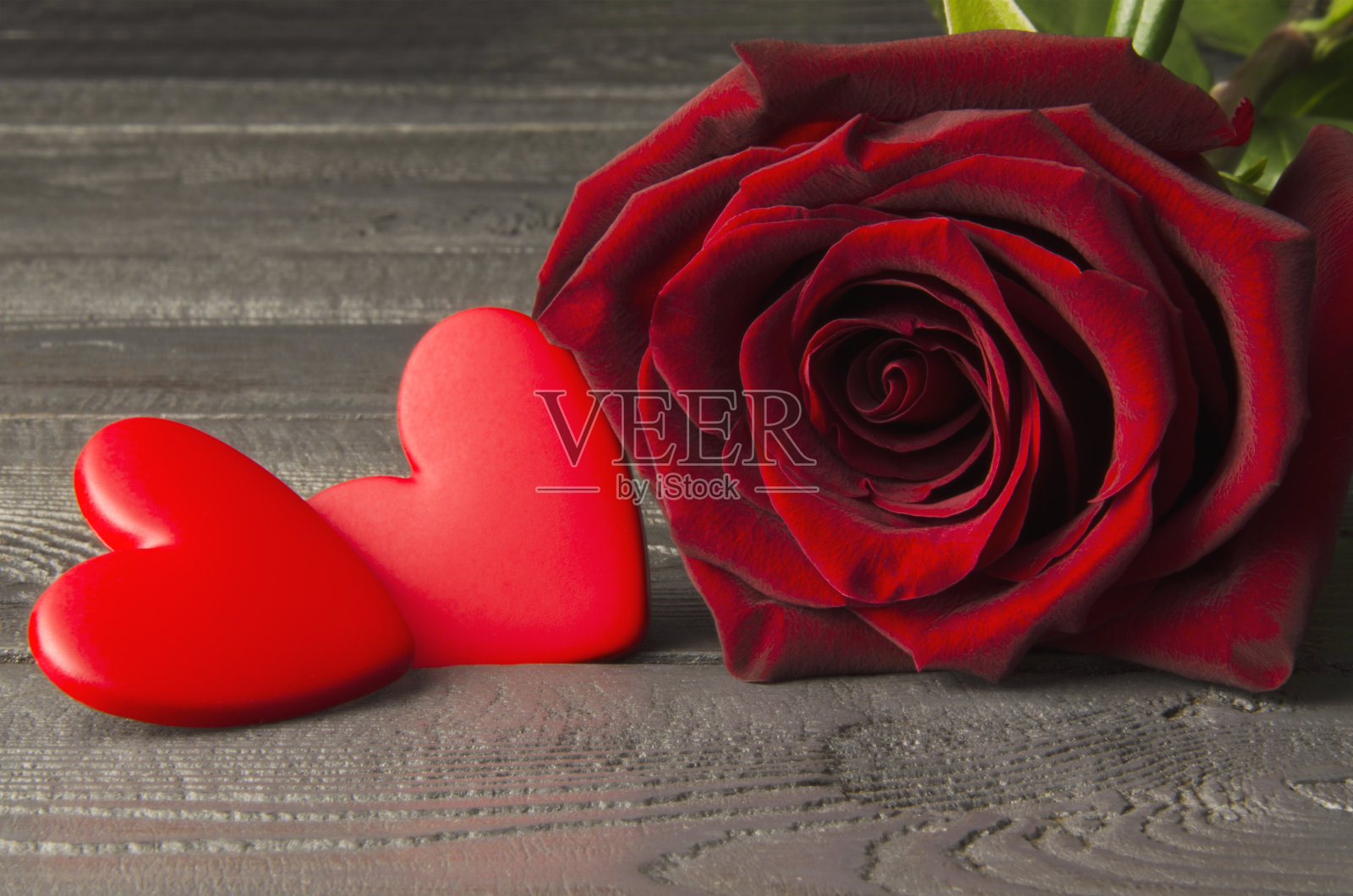 木制背景上的玫瑰和两颗心。情人节照片摄影图片