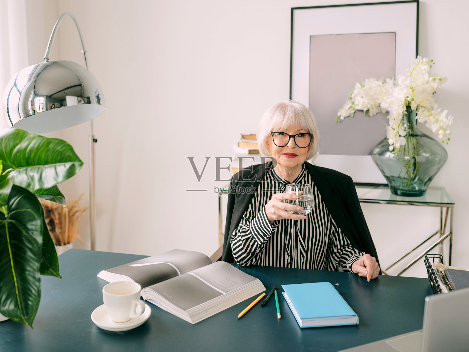 高级漂亮的白发女士在办公室里喝水。工作，资深人，水平衡，找到解决方案，体验理念照片摄影图片