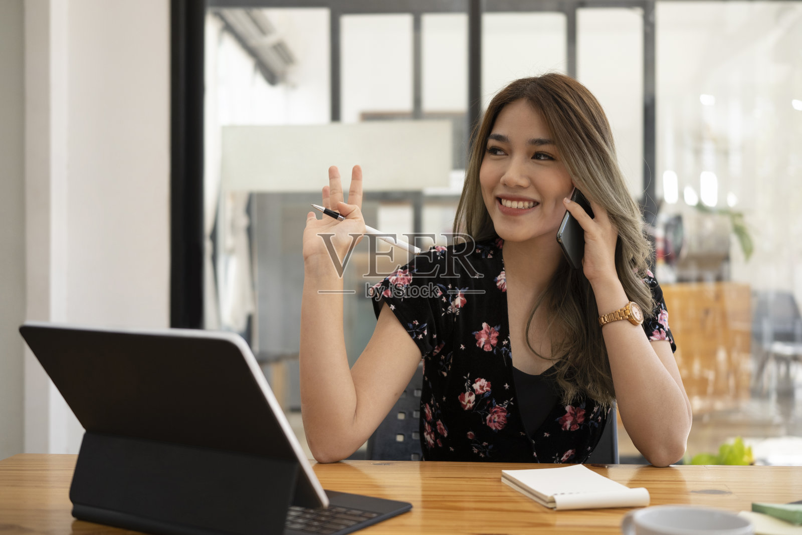 友好的亚洲女商人问候同事，而通话的移动电话。照片摄影图片