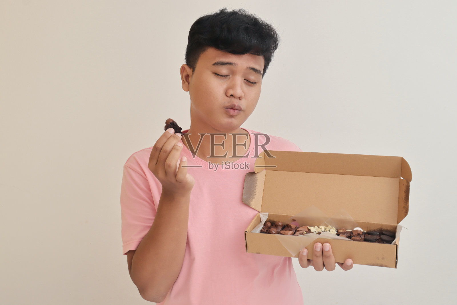 亚洲男人拿着一包自制饼干照片摄影图片