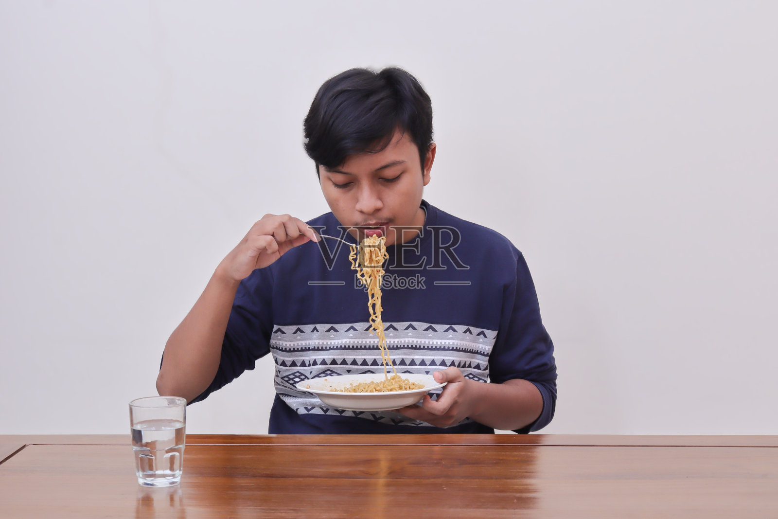 饥饿的亚洲男子吃方便面照片摄影图片