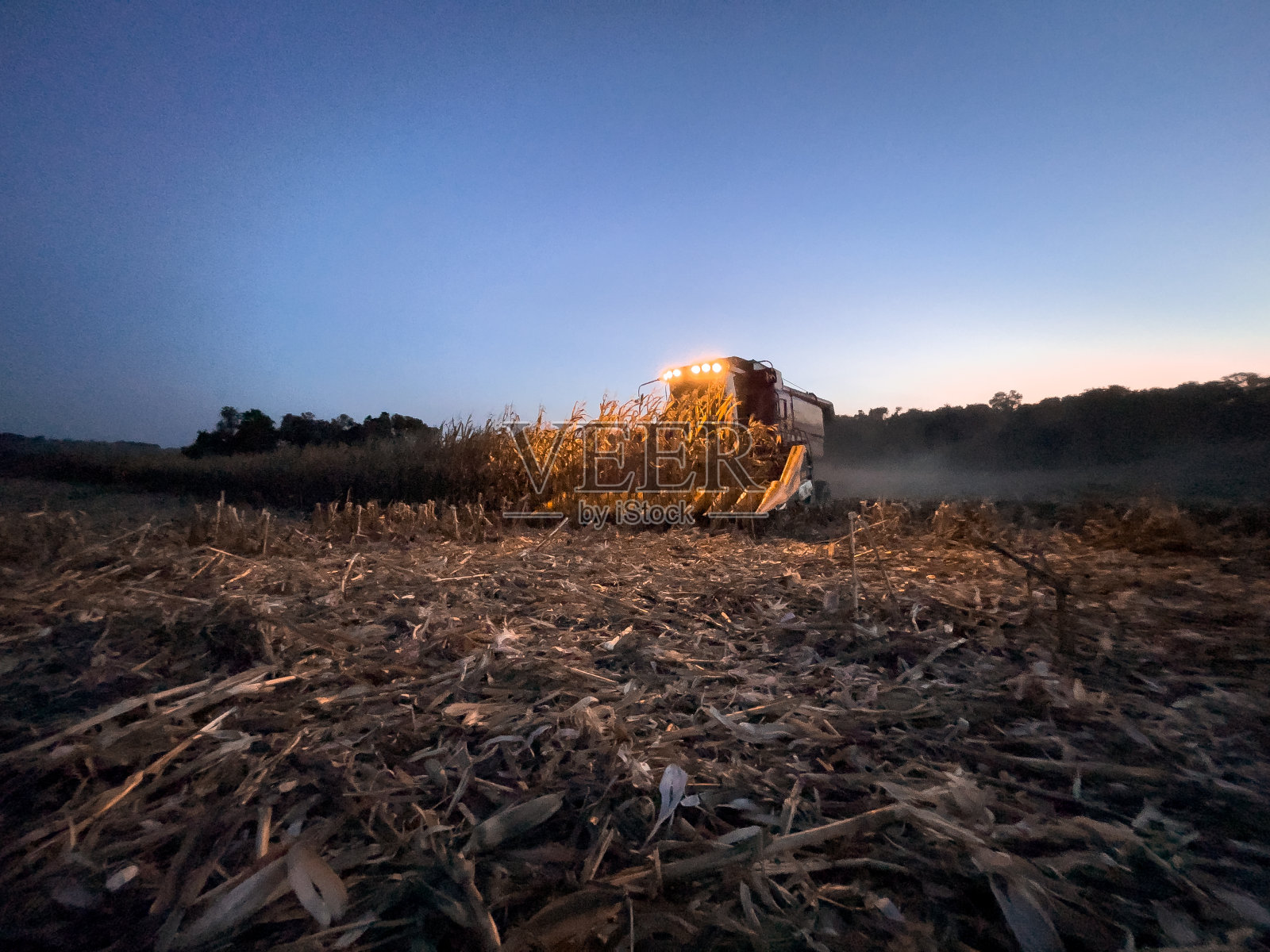 联合收割机在夕阳下收割谷物照片摄影图片