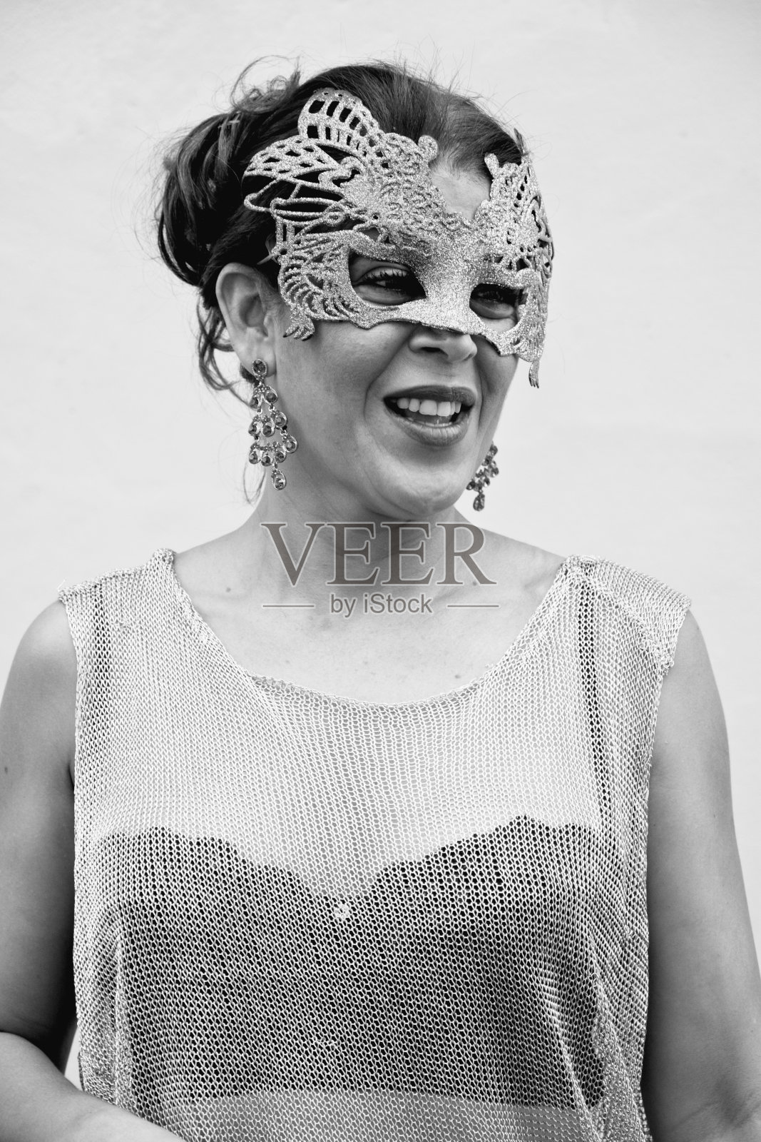 在灯光背景下，一个女人戴着威尼斯狂欢节面具的肖像。照片摄影图片