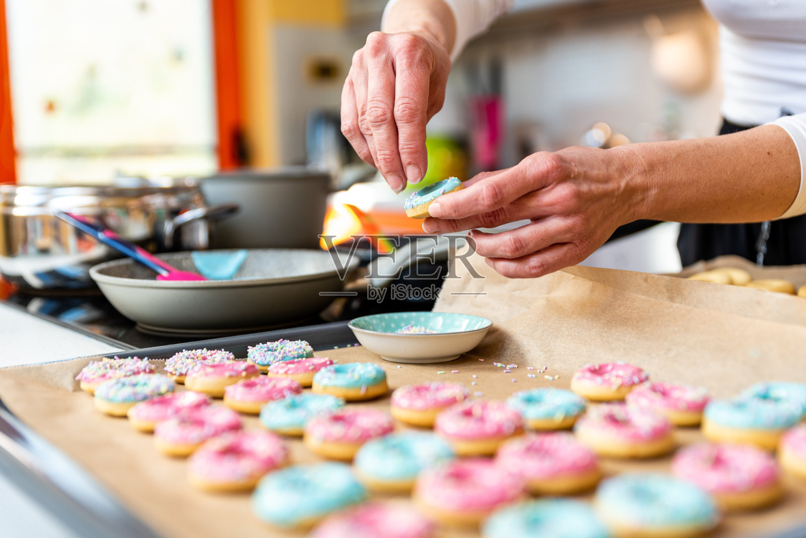 女人撒了成千上万个五颜六色的自制甜甜圈照片摄影图片