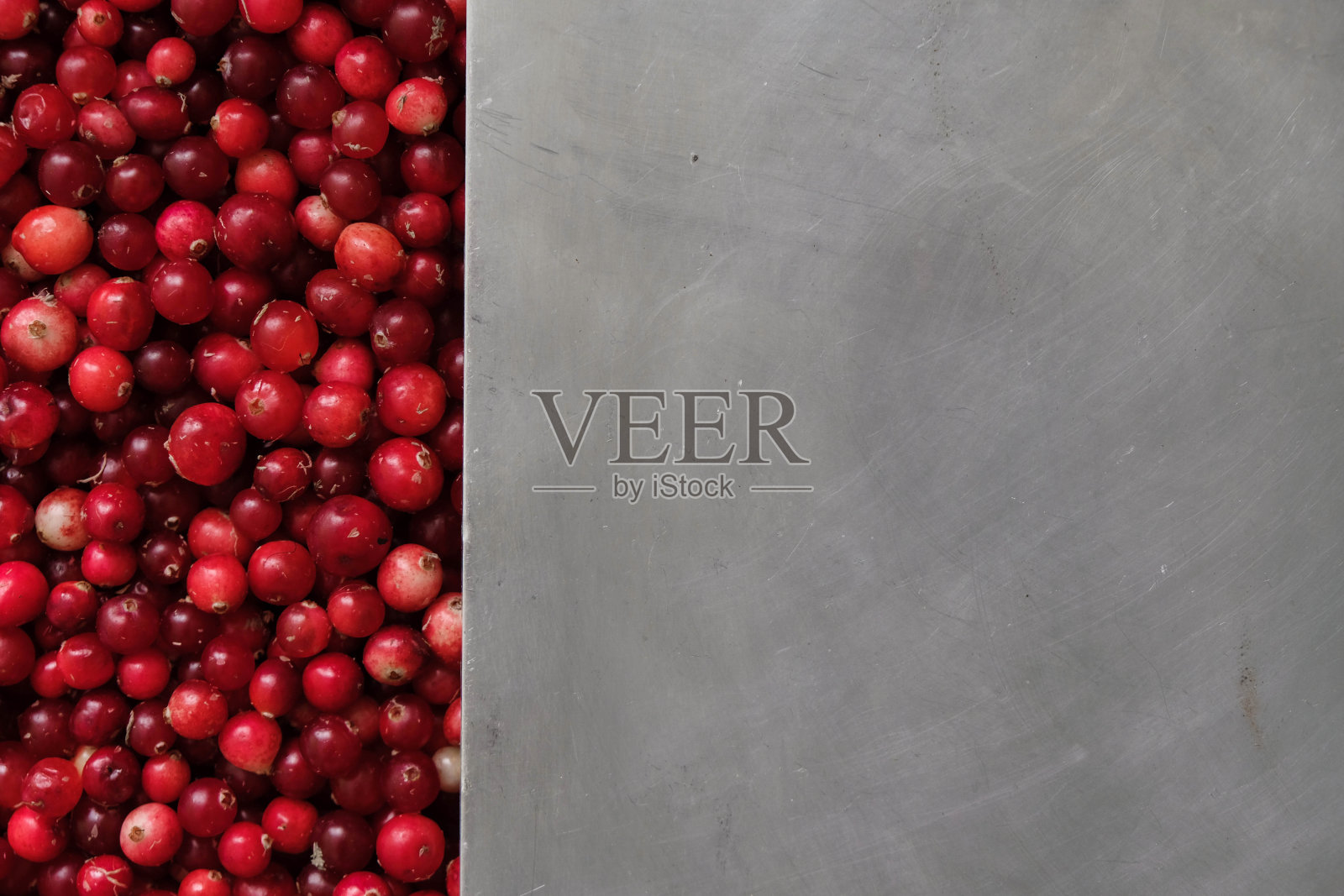 钢铁表面的红蔓越莓。副本的空间。照片摄影图片