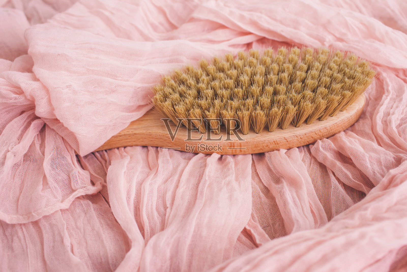 木刷在粉红色的背景干按摩。侘寂的美学。天然材料。照片摄影图片
