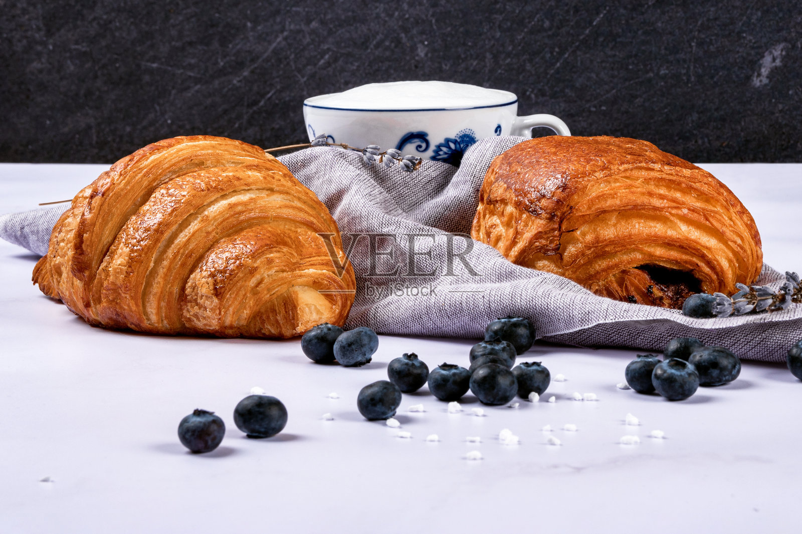 羊角面包和甜糕点充满了巧克力，在大理石纹理背景上的新鲜浆果。照片摄影图片