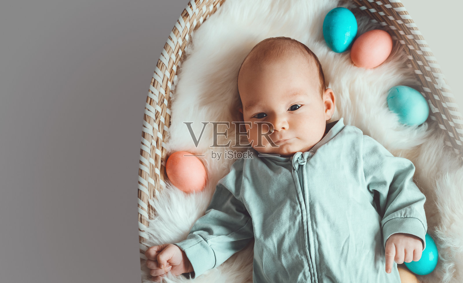 可爱的复活节小兔子。小男孩长着兔子耳朵，复活节彩蛋装在柳条筐里，里面有白色的皮毛。象征复活节假期，出生，春天，宗教。照片摄影图片