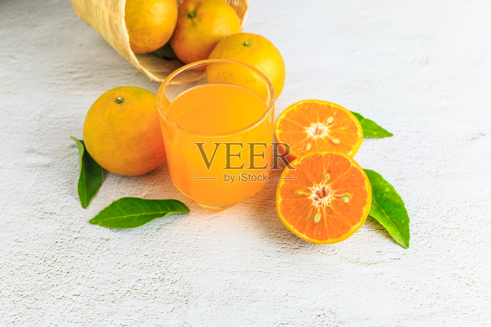 鲜橙汁和橙果放在篮子里照片摄影图片