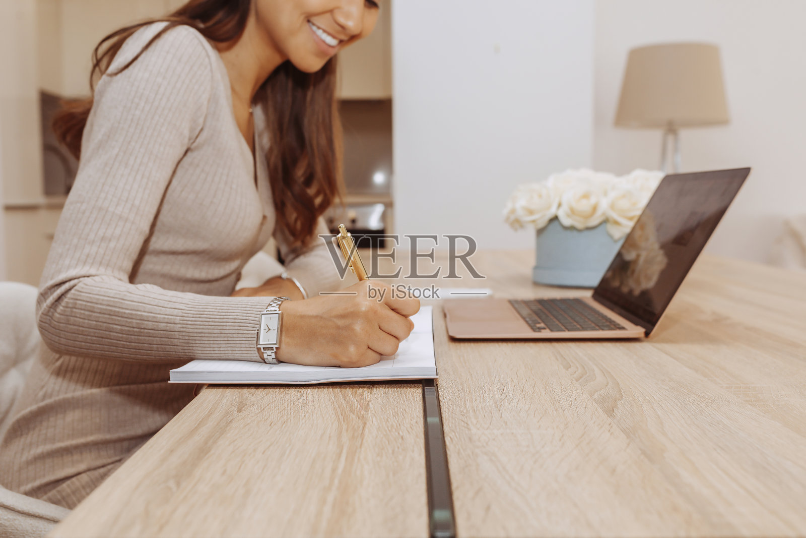 女人写在笔记本上接近在家庭办公室工作照片摄影图片