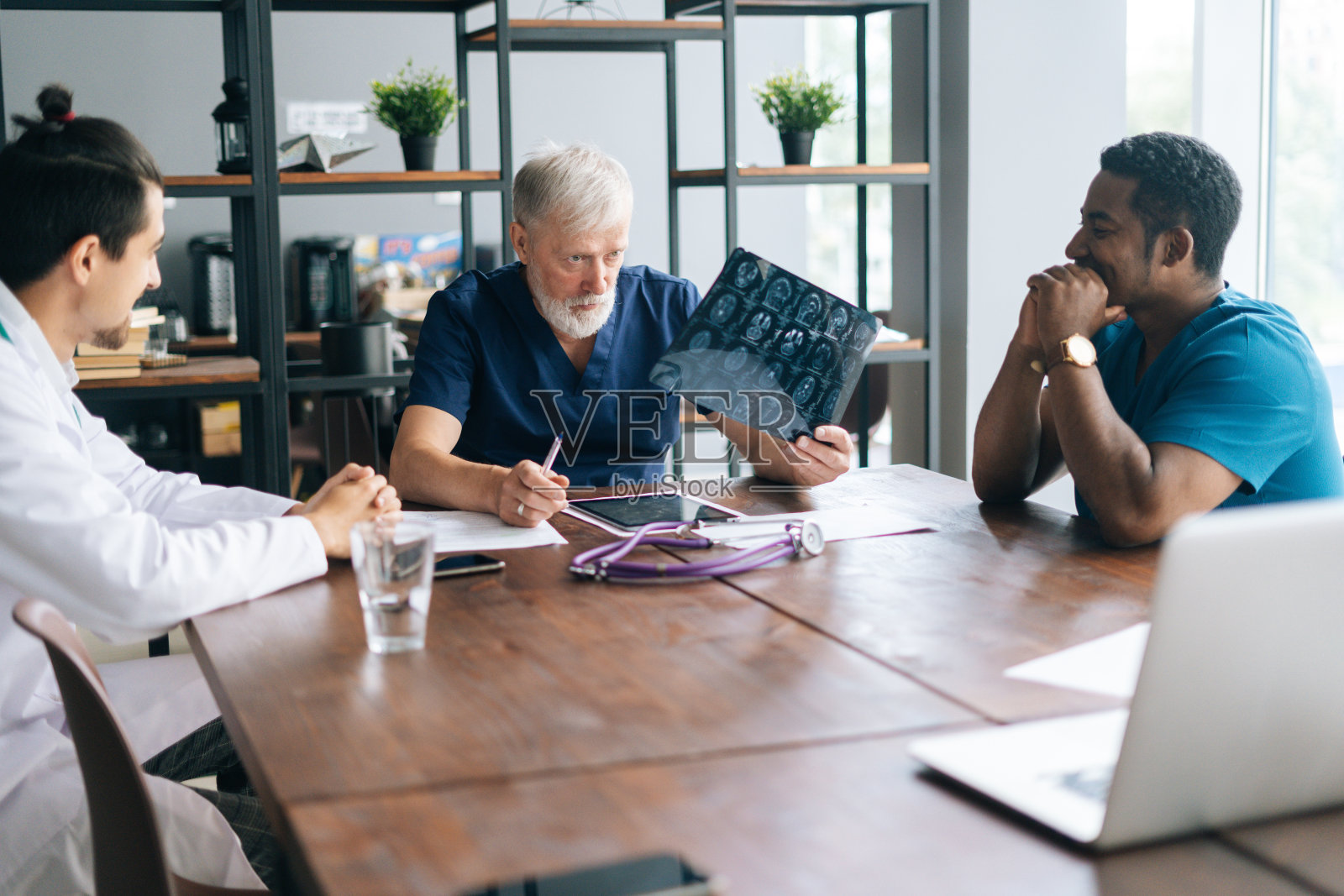 医学会议期间，多民族医学专家在胸部x光片上讨论。照片摄影图片